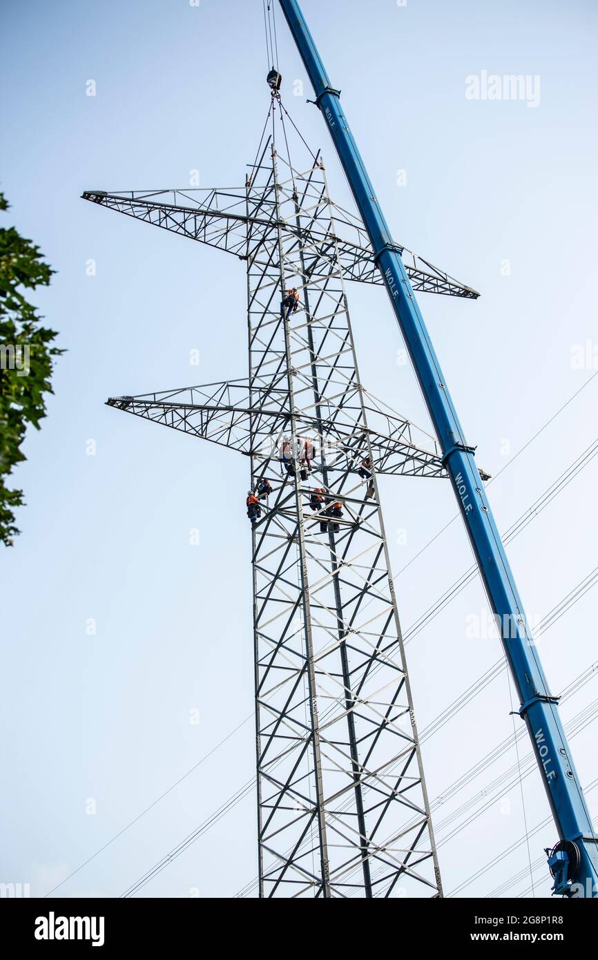 Auf einem Feld zwischen Kaarst und Düsseldorf bauen Mitarbeiter der Firma SPIE Leitungsbau einen Elektrizitätsmast auf. Wie Playmobil-Männchen sehen d Stock Photo
