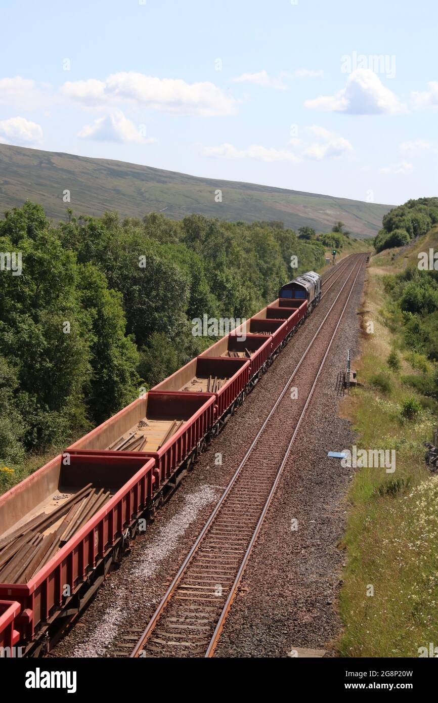 Wagons on freight train on side of the Mallerstang valley soon after passing through Birkett tunnel on Settle to Carlisle railway line 20th July 2021. Stock Photo