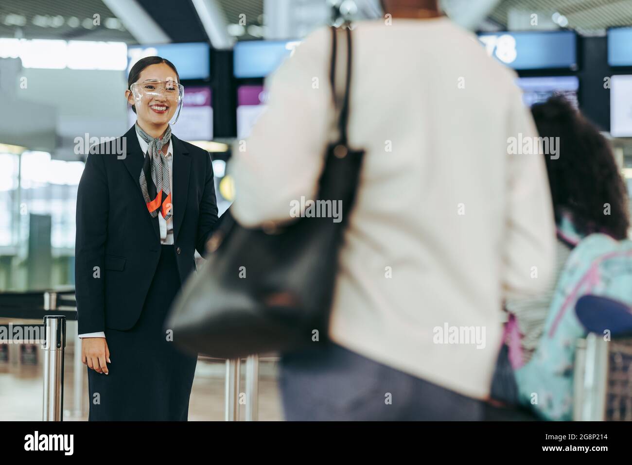 Airlines attendant with face shield standing at airport. Airport