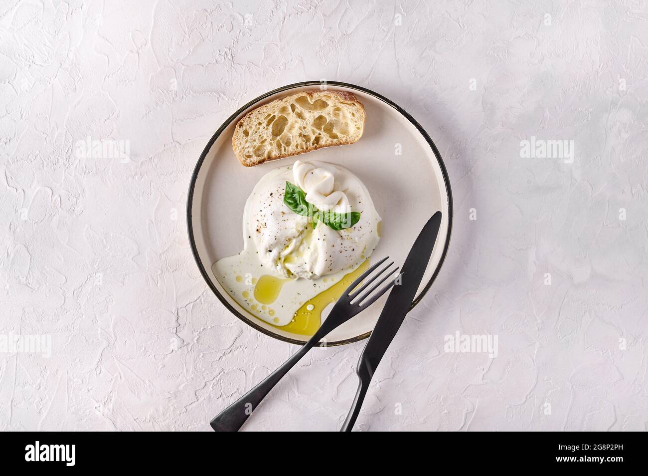 Italian cut burrata cheese with ciabatta bread and olive oil on white