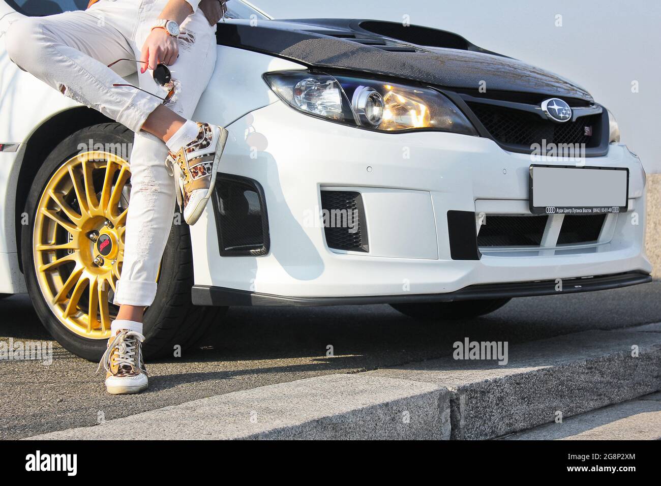 Kiev, Ukraine - March 25, 2015: Subaru Impreza WRX STI. Girl in colored sneakers and in white trousers. Girl on car background. Car and girl Stock Photo