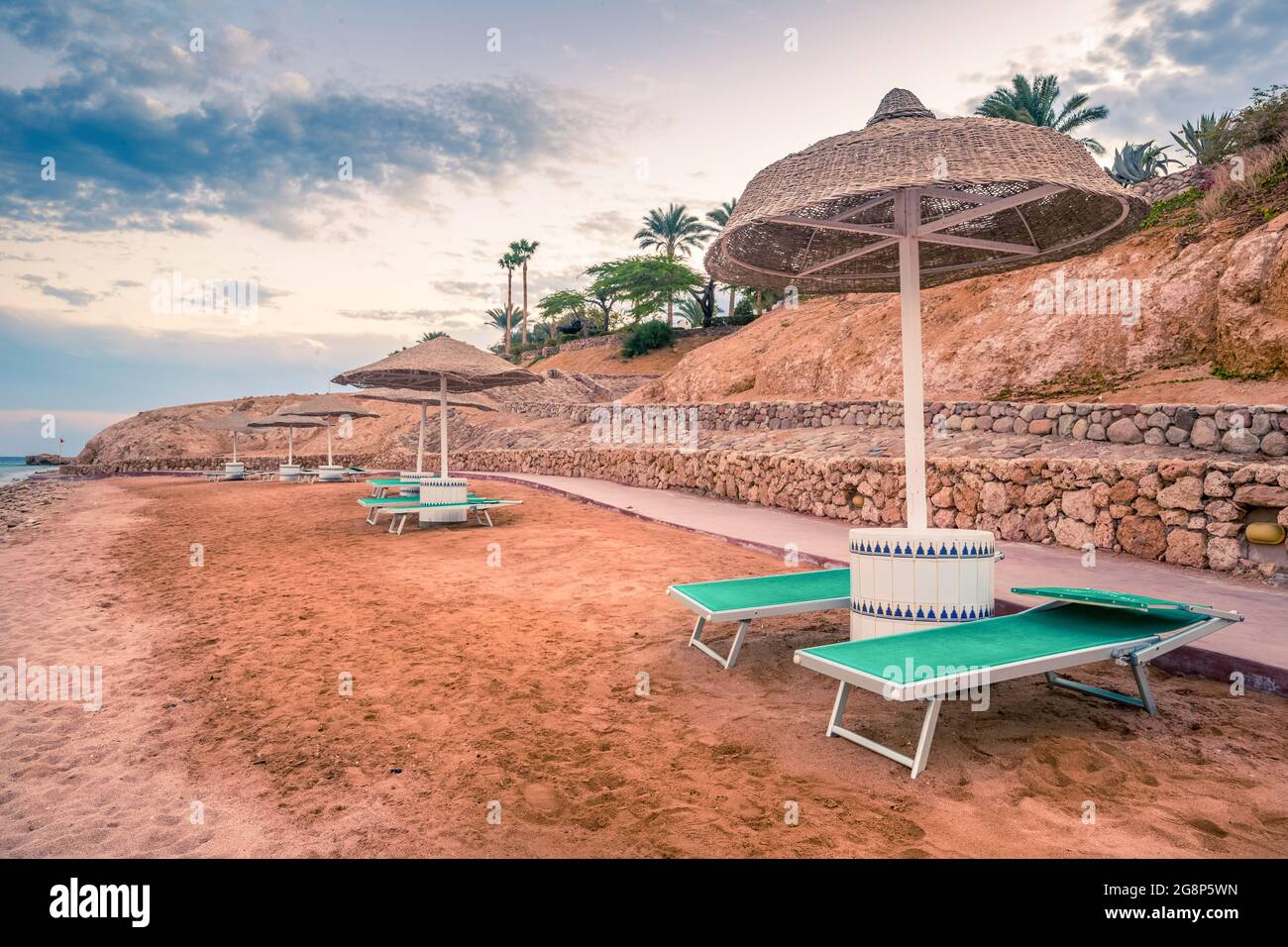 Straw umbrellas and sunbeds on the wonderful tropical beach. Stock Photo