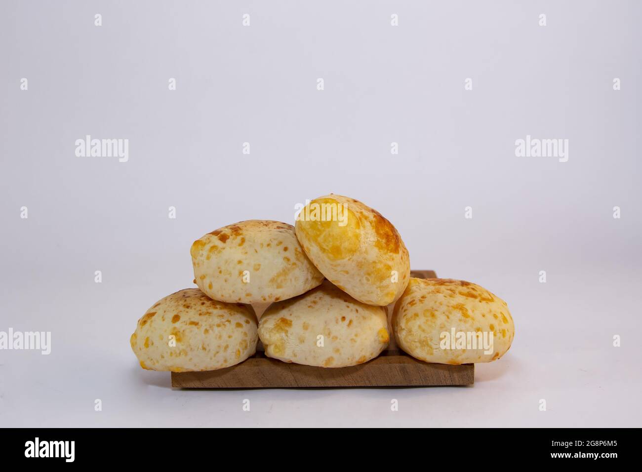 Pile of delicious Paraguayan chipa bread on a wooden tray with an isolated background Stock Photo