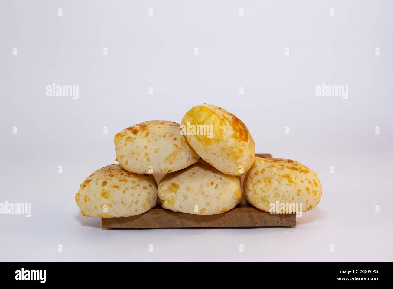 Pile of delicious Paraguayan chipa bread on a wooden tray with an isolated background Stock Photo