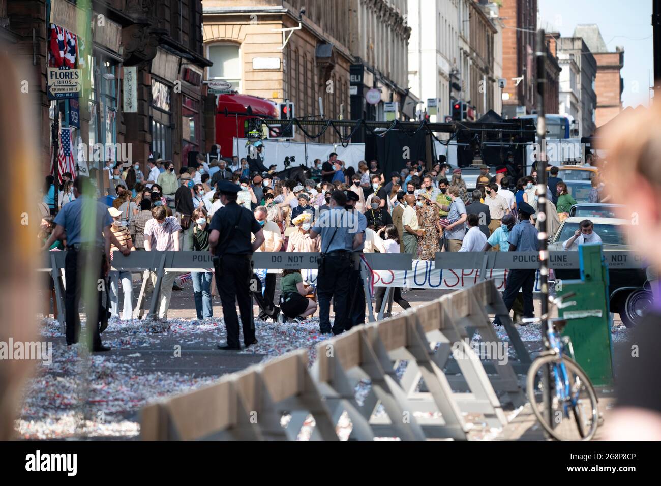 Glasgow, Scotland, UK. 21 July 2021.  PICTURED: The angry crowd/mob film scene which is in between takes in the side streets of Glasgow. Filming on the set of Indiana Jones 5 in the middle of Glasgow city centre as the Hollywood blockbuster sets up Glasgow as New York City. A full production can be seen, with a large cast, producers and extras. The city centre has been changed so that all the shop fronts and building look like 1959 America. Credit: Colin Fisher Stock Photo