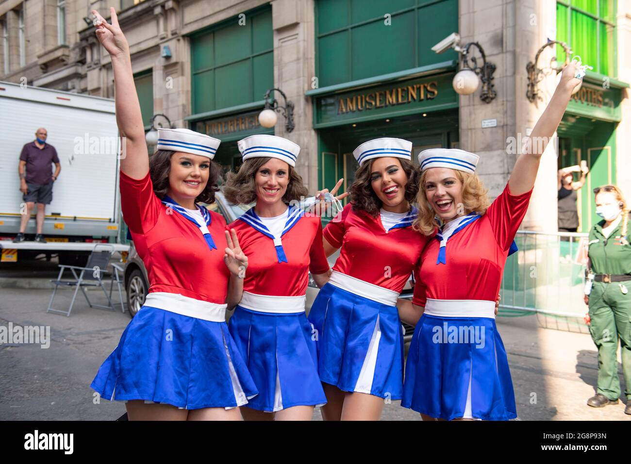 Glasgow, Scotland, UK. 21 July 2021.  PICTURED: A group of cheerleaders seen taking a break in between takes on the film set. Filming on the set of Indiana Jones 5 in the middle of Glasgow city centre as the Hollywood blockbuster sets up Glasgow as New York City. A full production can be seen, with a large cast, producers and extras. The city centre has been changed so that all the shop fronts and building look like 1959 America. Credit: Colin Fisher Stock Photo