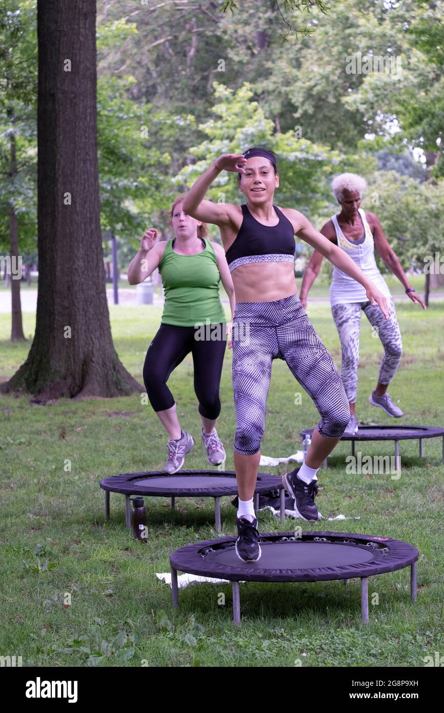 A fit woman with great abs participates in a rebounding workout in a park in Queens, New York City. Stock Photo