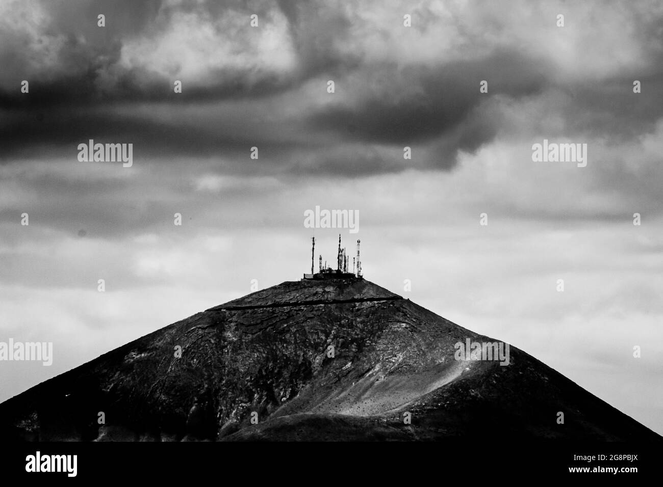 Telecommunication tower on the top of a mountain in black and white Stock Photo