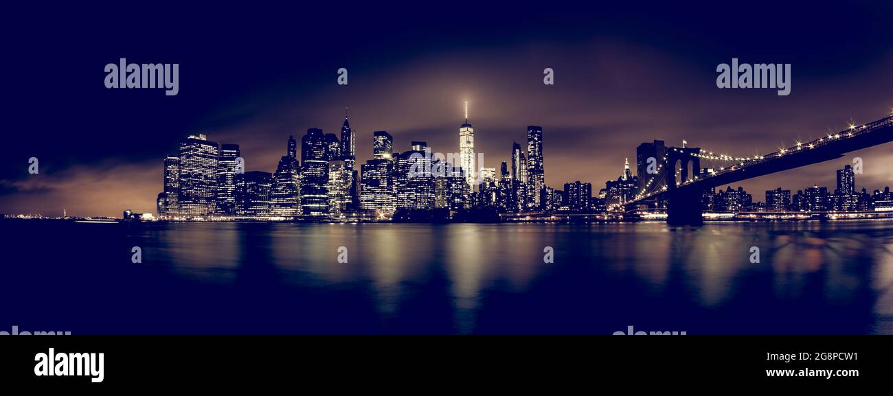 Manhattan bridge and New York City downtown skyline at night with ...
