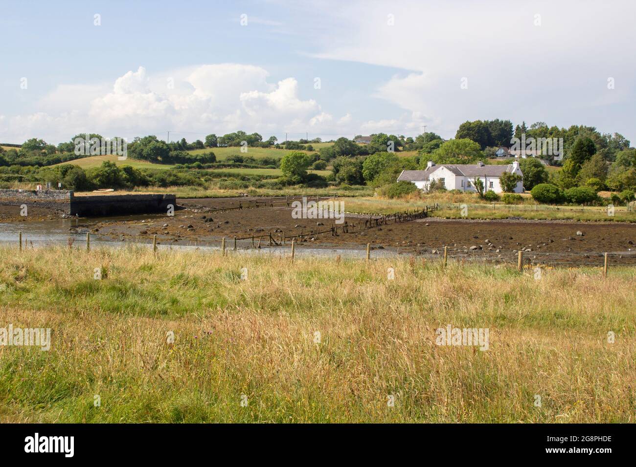 21 July 2021 A small white bungalow with its own wooden jetty sits at the water's edge near Gibbs Island on Strangford Lough in County Down Northern I Stock Photo