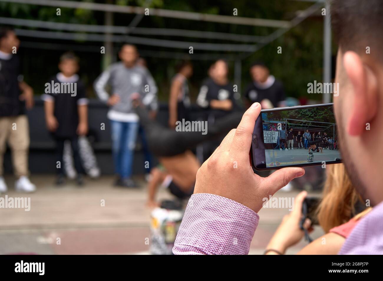 MEDELLIN, COLOMBIA - Nov 30, 2019: A young man recording the street dance performance in Medellin, Colombia Stock Photo