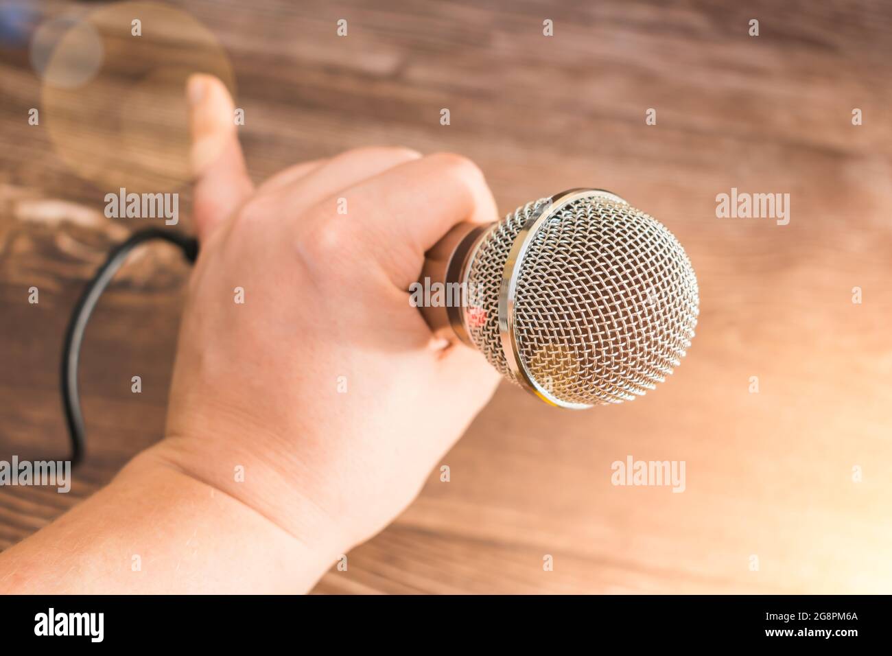 The singer holds in his hand a professional microphone for singing or