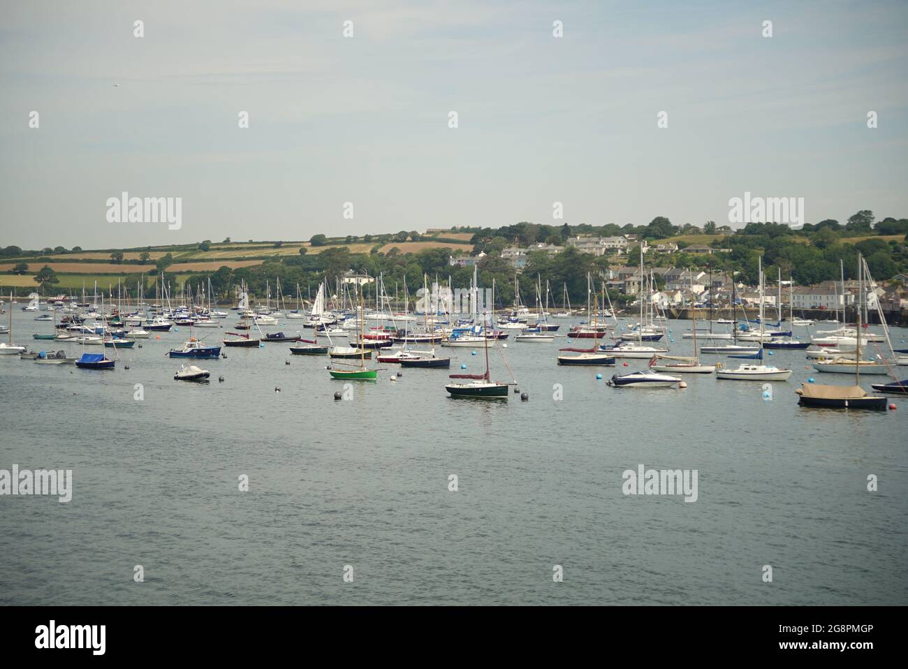 Boats moored in Falmout bay near harbour with land in background Stock Photo