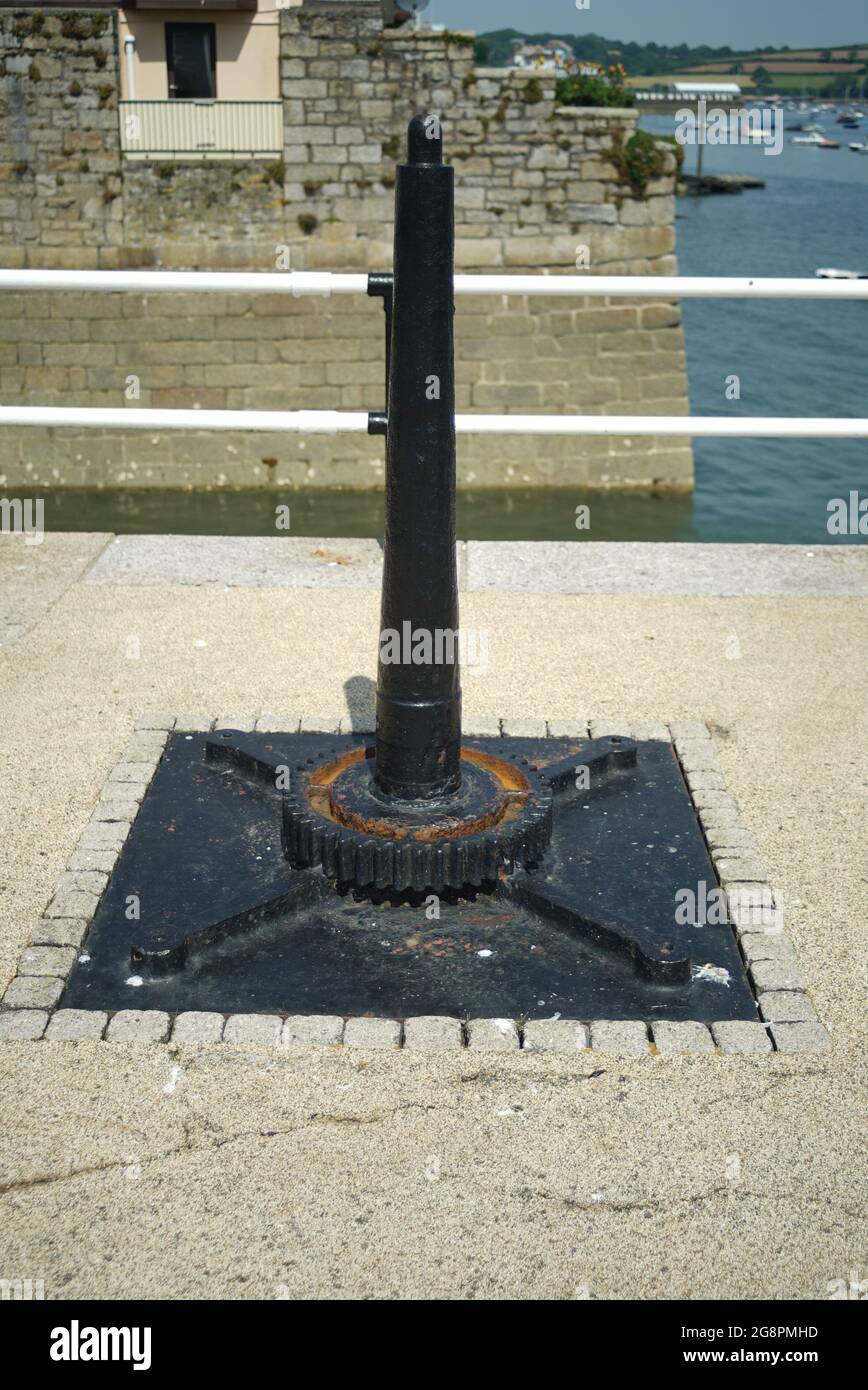 harbor winch post disused painted black surrounded by block stone Stock Photo