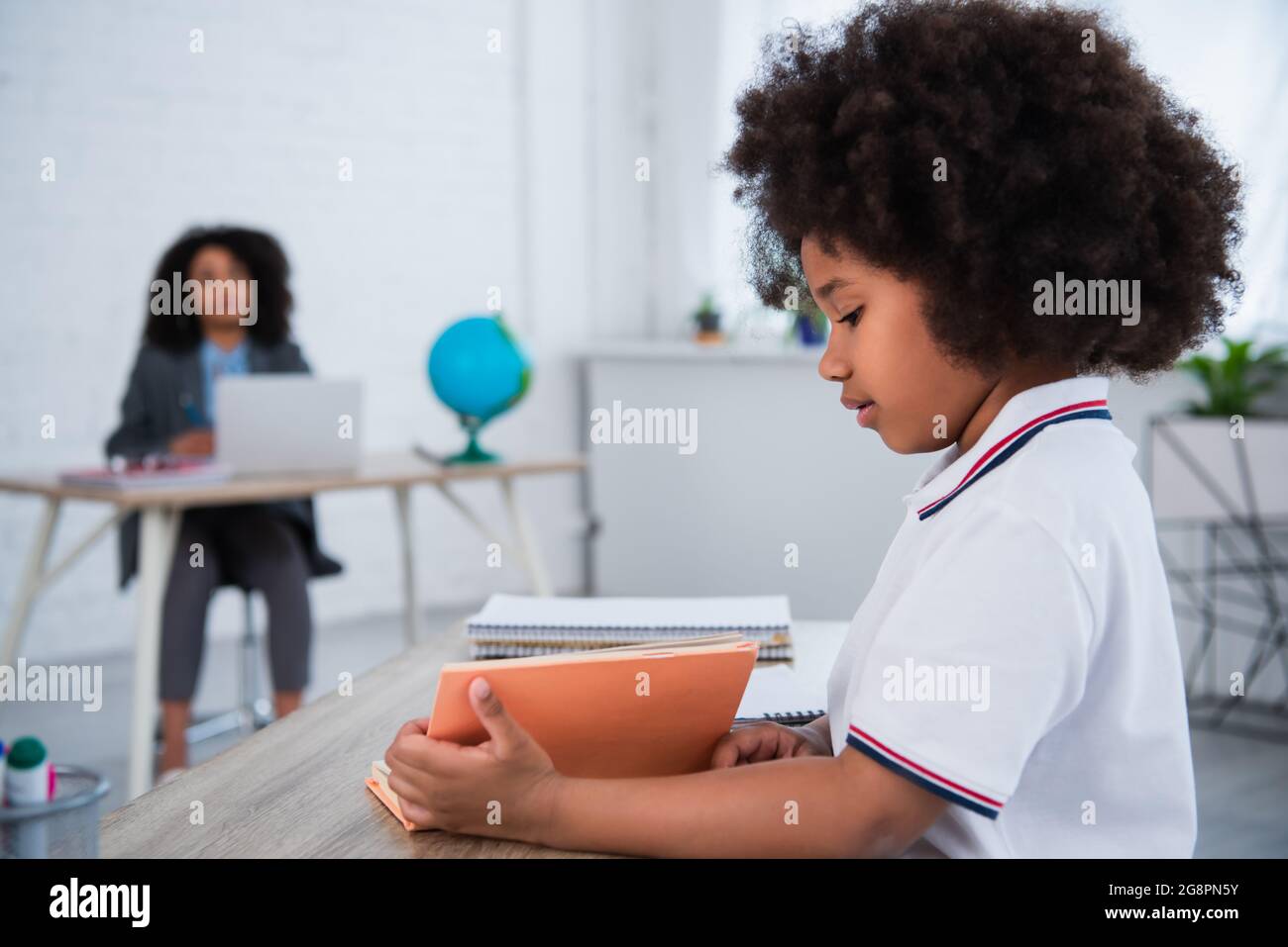 Side view of african american schoolgirl reading book in school Stock ...