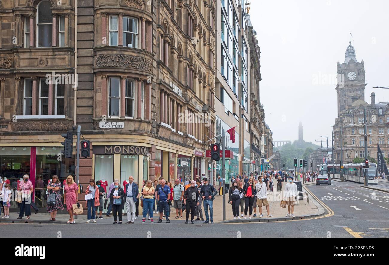 Princes Street, Edinburgh, Scotland, UK weather. 22nd July 2021. Dull  and dreary weather in Scottish capital, the overnight haar taking its time to clear from the higher viewpoints such as the Castle, Calton Hill and Arthur's Seat.Temperature 21 degrees centigrade. Pictured: shoppers and people on Princes Street with a misty Calton Hill in background. Credit: Arch White/Alamy Live News Stock Photo