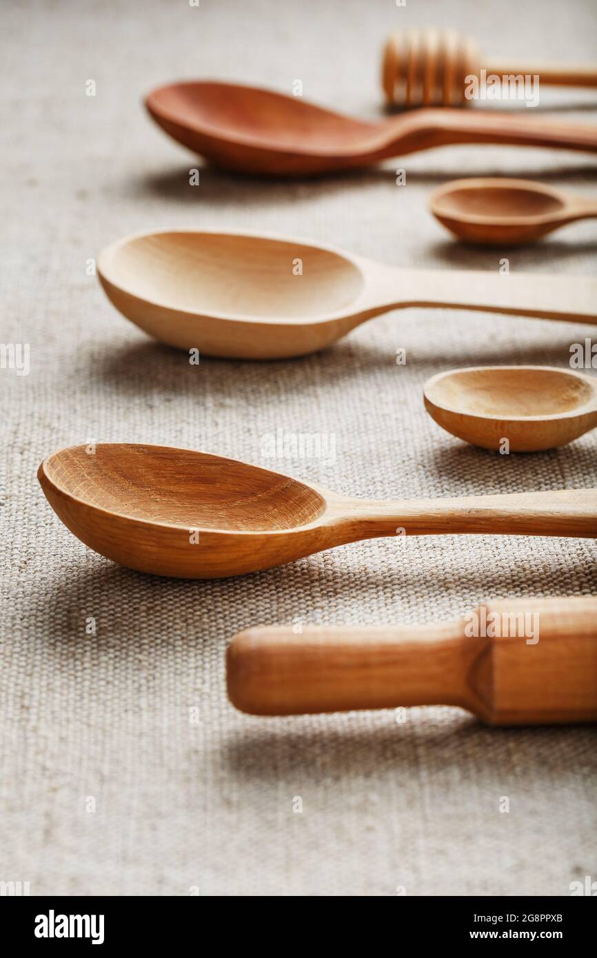 Natural wood spoons in a row on burlap fabric. Natural natural materials. Caring for the environment Stock Photo
