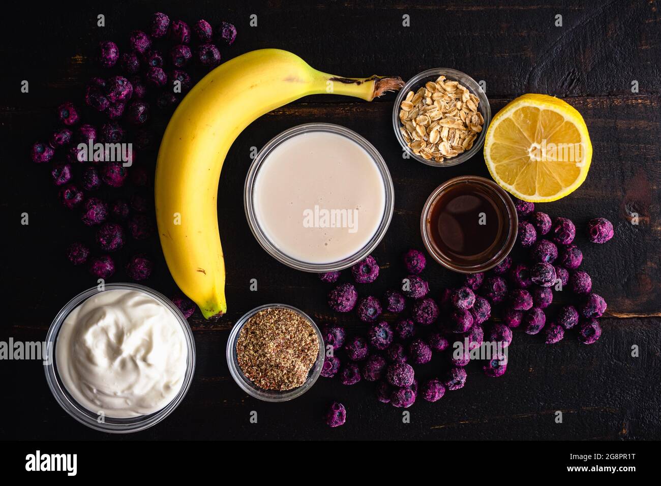Healthy Blueberry Muffin Breakfast Smoothie Ingredients: Raw smoothie ingredients including frozen blueberries, bananas, and rolled oats Stock Photo