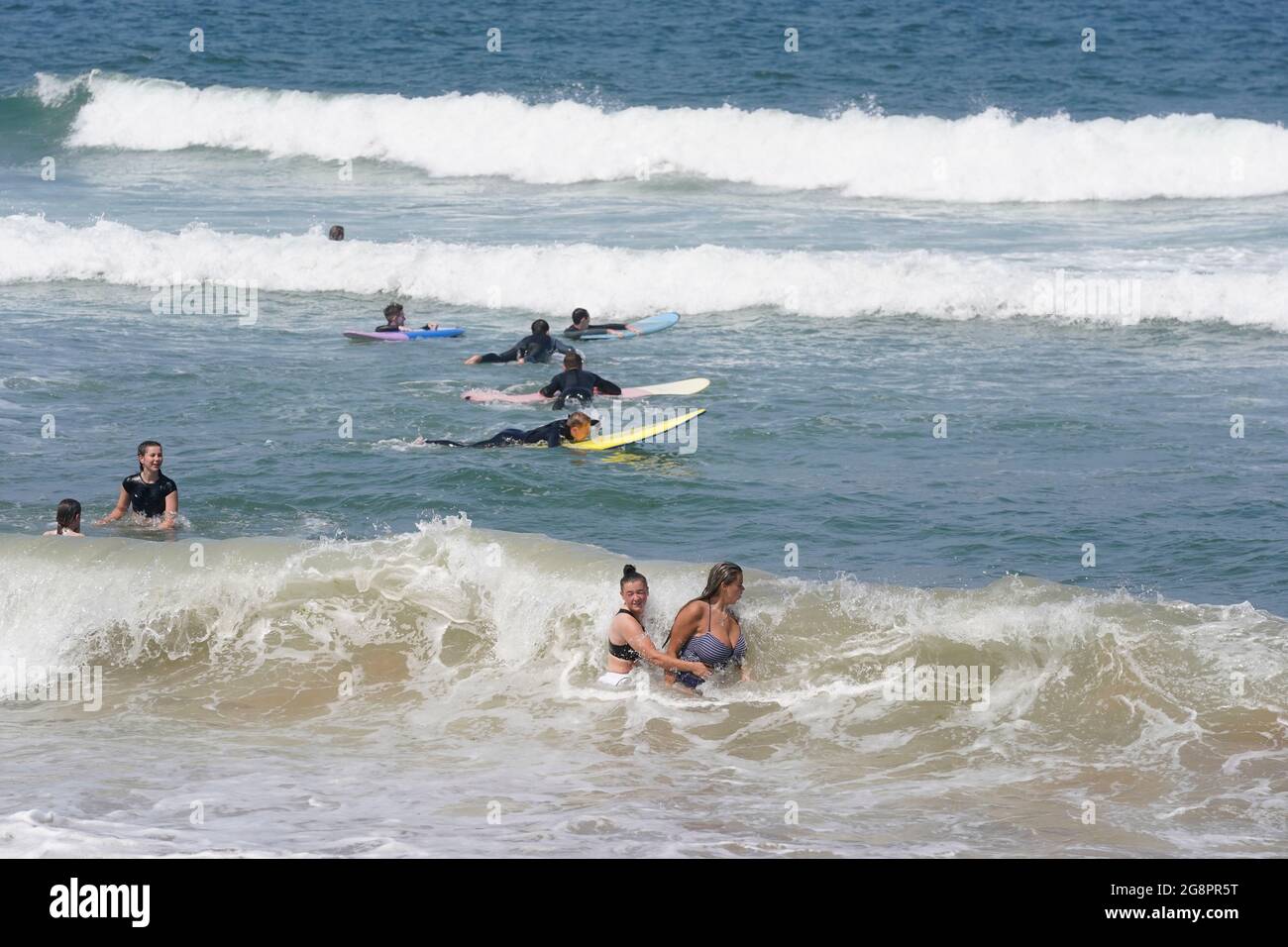 People in the sea at Saltburn-by-the-Sea in North Yorkshire. A heatwave which has baked the UK over the last few days is expected to end with thunderstorms across much of England and Wales this weekend, forecasters have warned. Picture date: Thursday July 22, 2021. Stock Photo