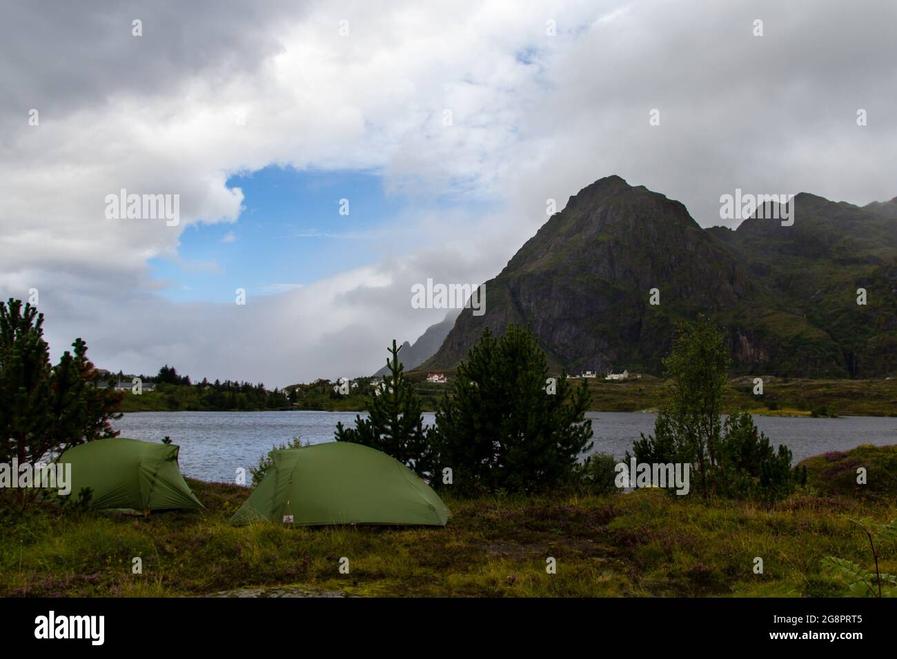 Green tents on the background of rocky mountains and a lake. Lofoten ...