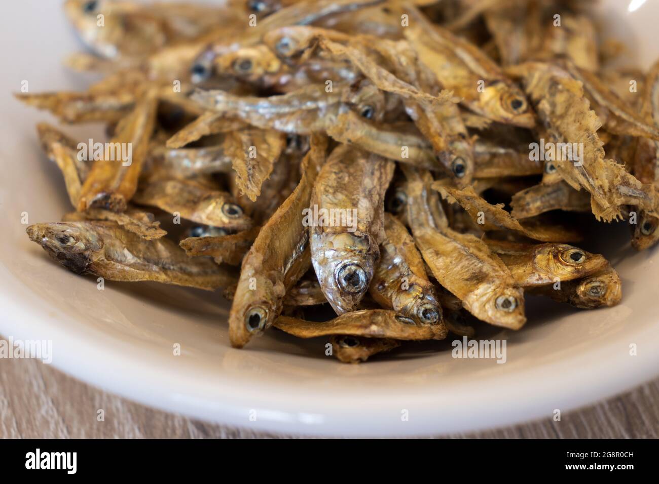 Closeup of dry charales over a white plate. Dried charales. Dried fish. Stock Photo