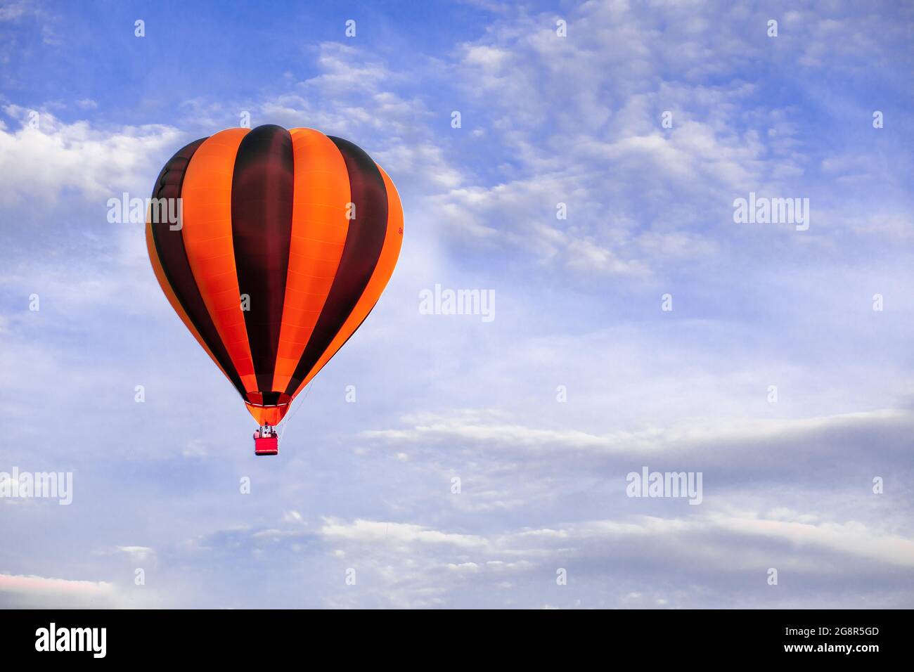 Red hot air balloon flying on blue sky Stock Photo - Alamy