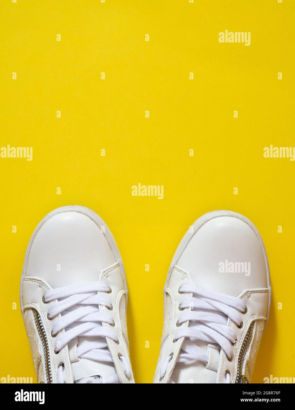 Clean White Women s Shoes Sneakers On Bright Yellow Surface Stock Photo