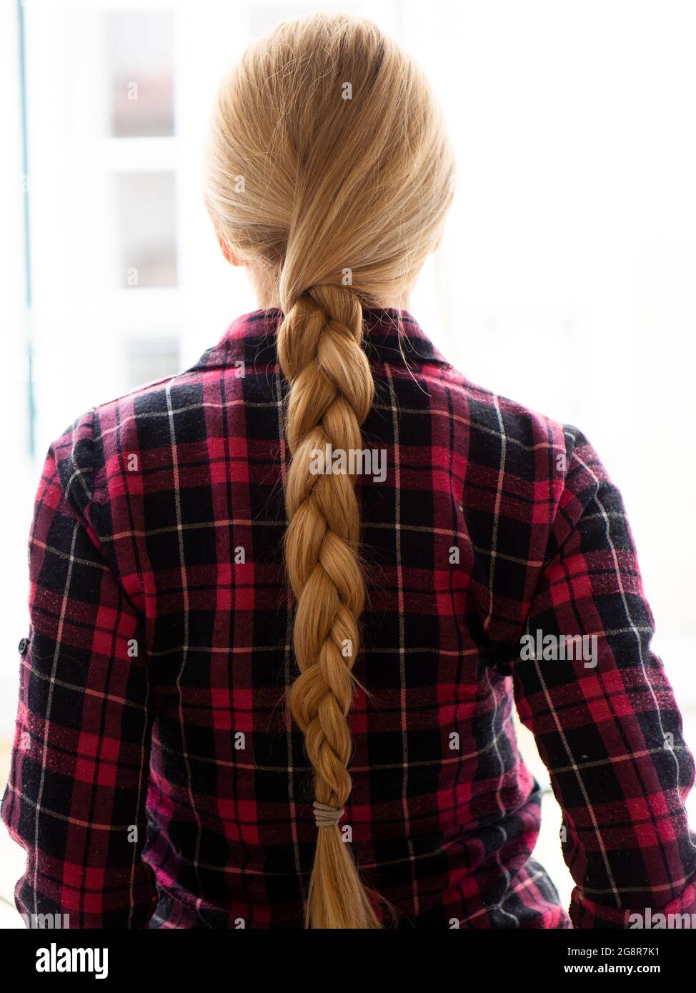 Woman with a braid wearing flanner shirt Stock Photo