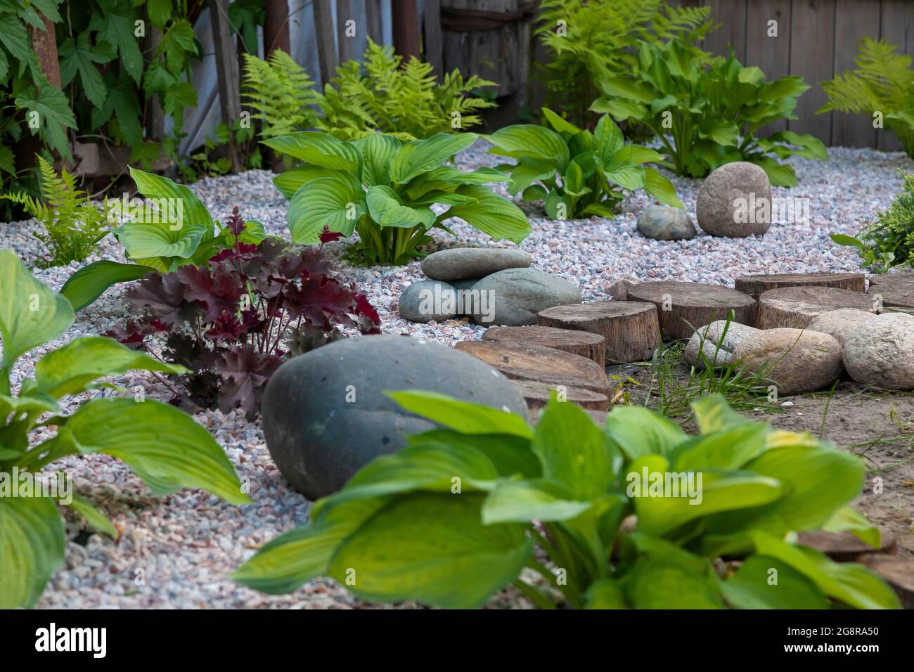 Rockery rock garden with big and small stones through which flowers ...