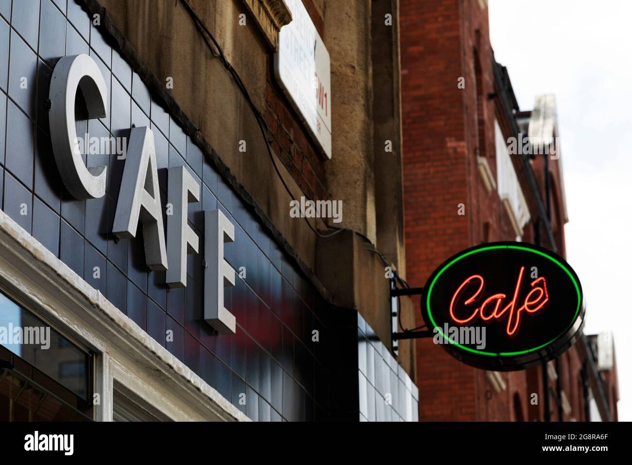 Sign for a cafe in London, England. A neon light advertises the cafe. Stock Photo