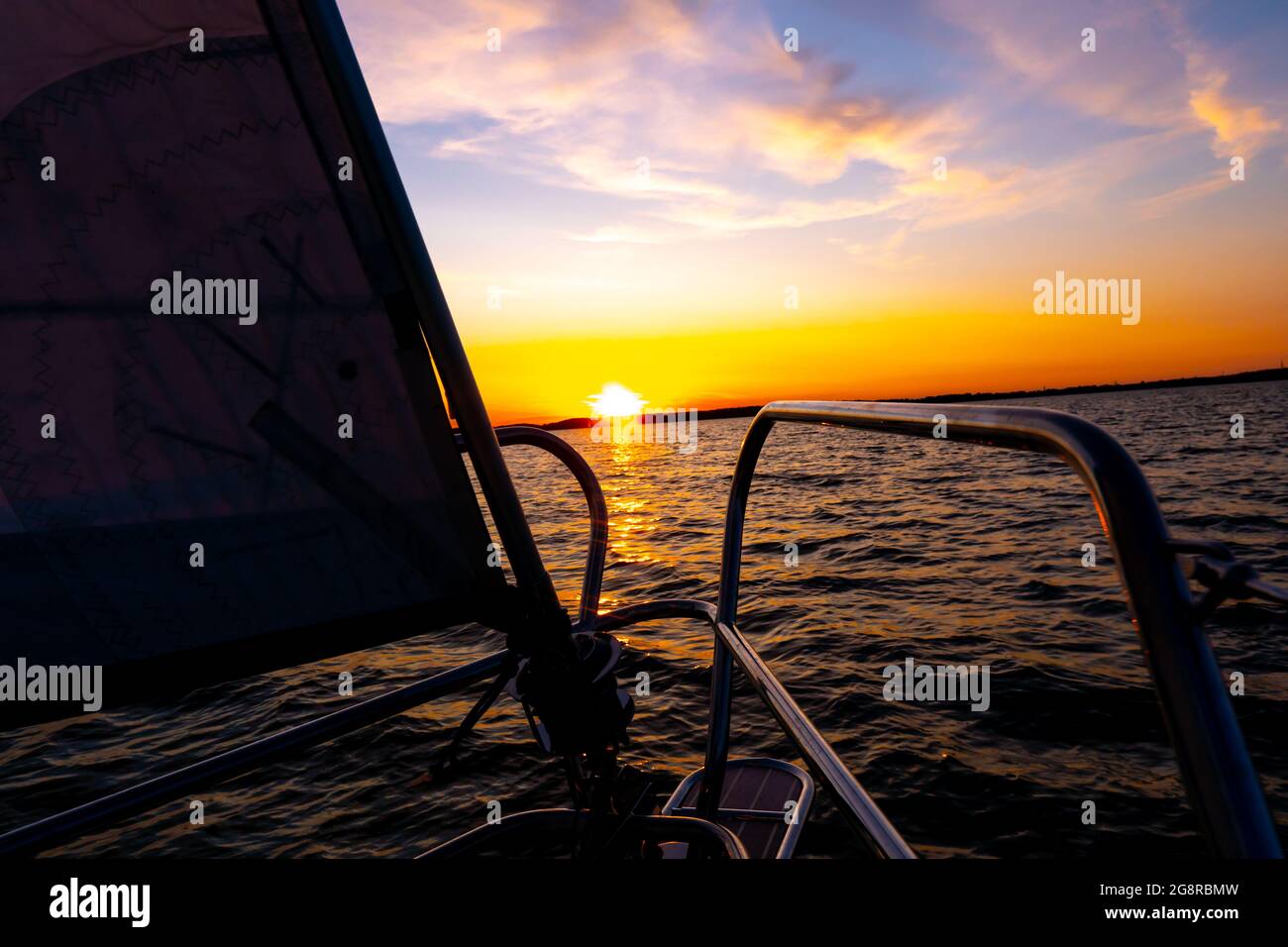 Yacht sailing in an open sea at sunset. Close-up view of the deck, mast ...