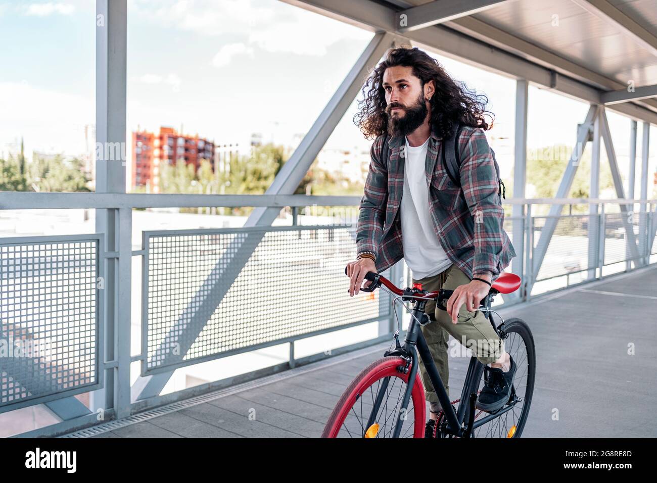 Handsome hipster man with long hair looking at front and riding his bike in the city Stock Photo - Alamy Handsome hipster man with long hair looking at front and riding his bike in the city Stock Photo - Alamy