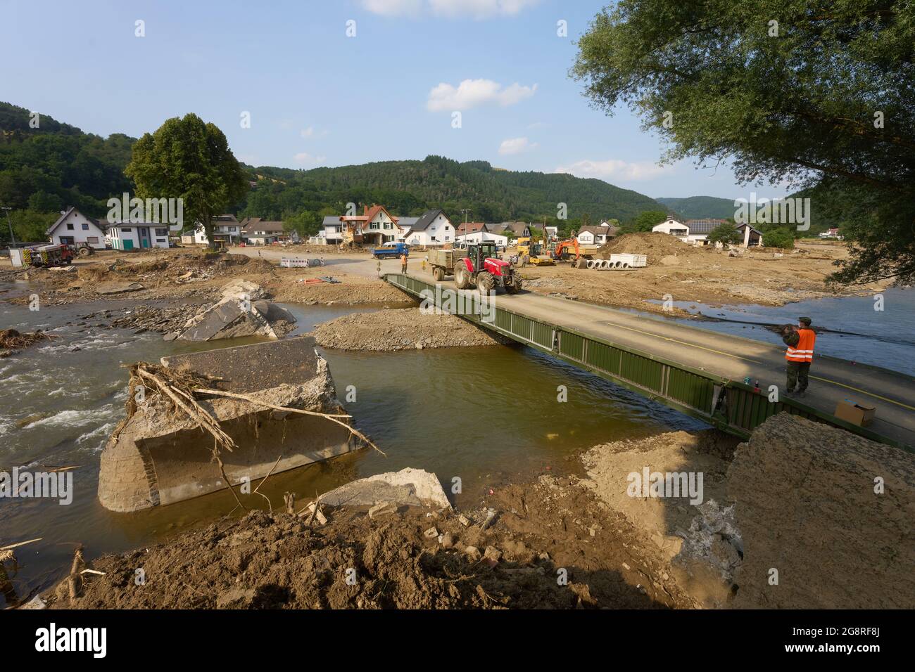 Insul, Germany. 22nd July, 2021. A tractor drives over a makeshift bridge in the community of Insul in the Ahr valley. The flooding of the Ahr river has left great damage in the village. Credit: Thomas Frey/dpa/Alamy Live News Stock Photo