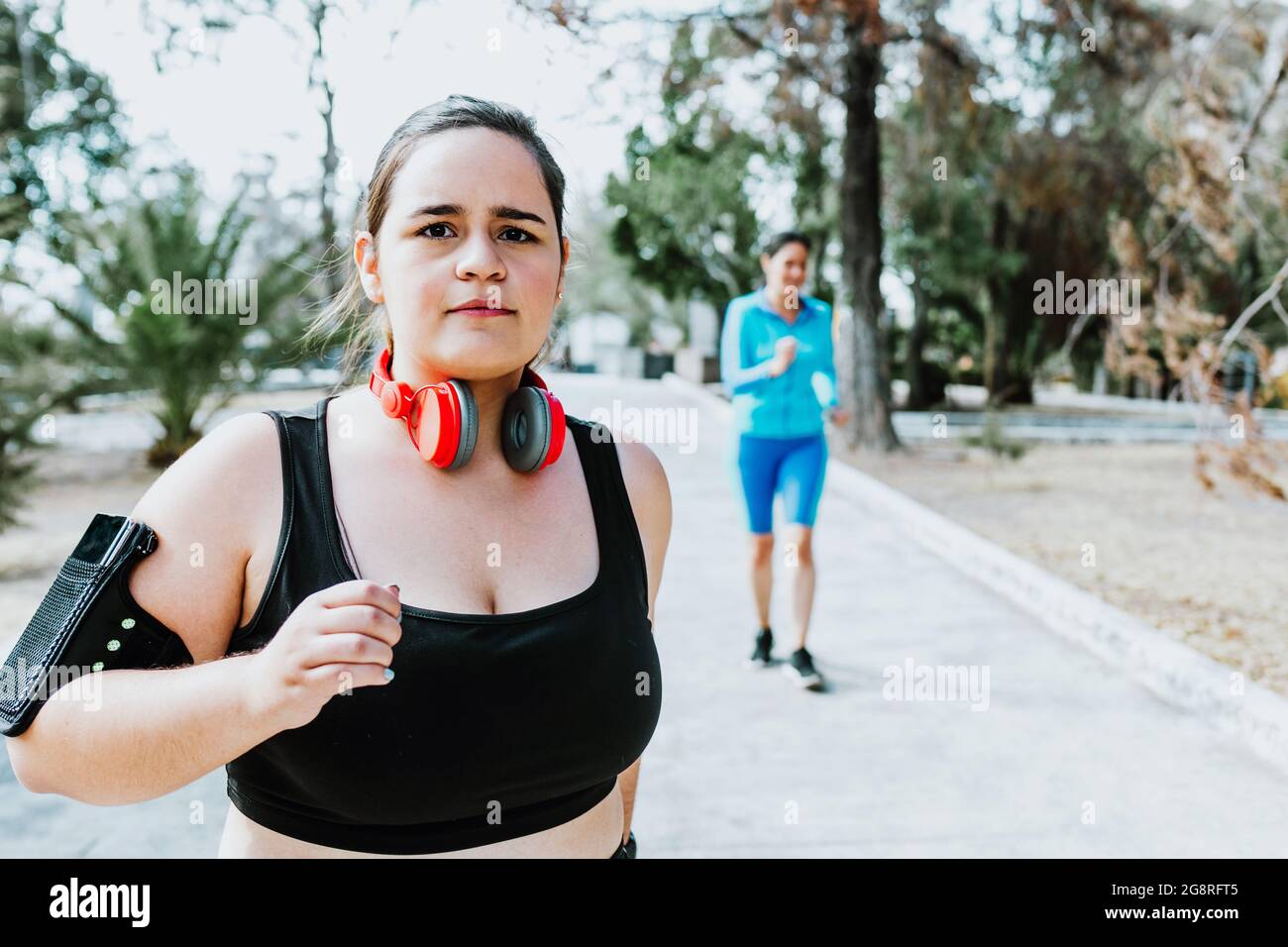 plus size young latin woman running in park in Mexico Stock Photo