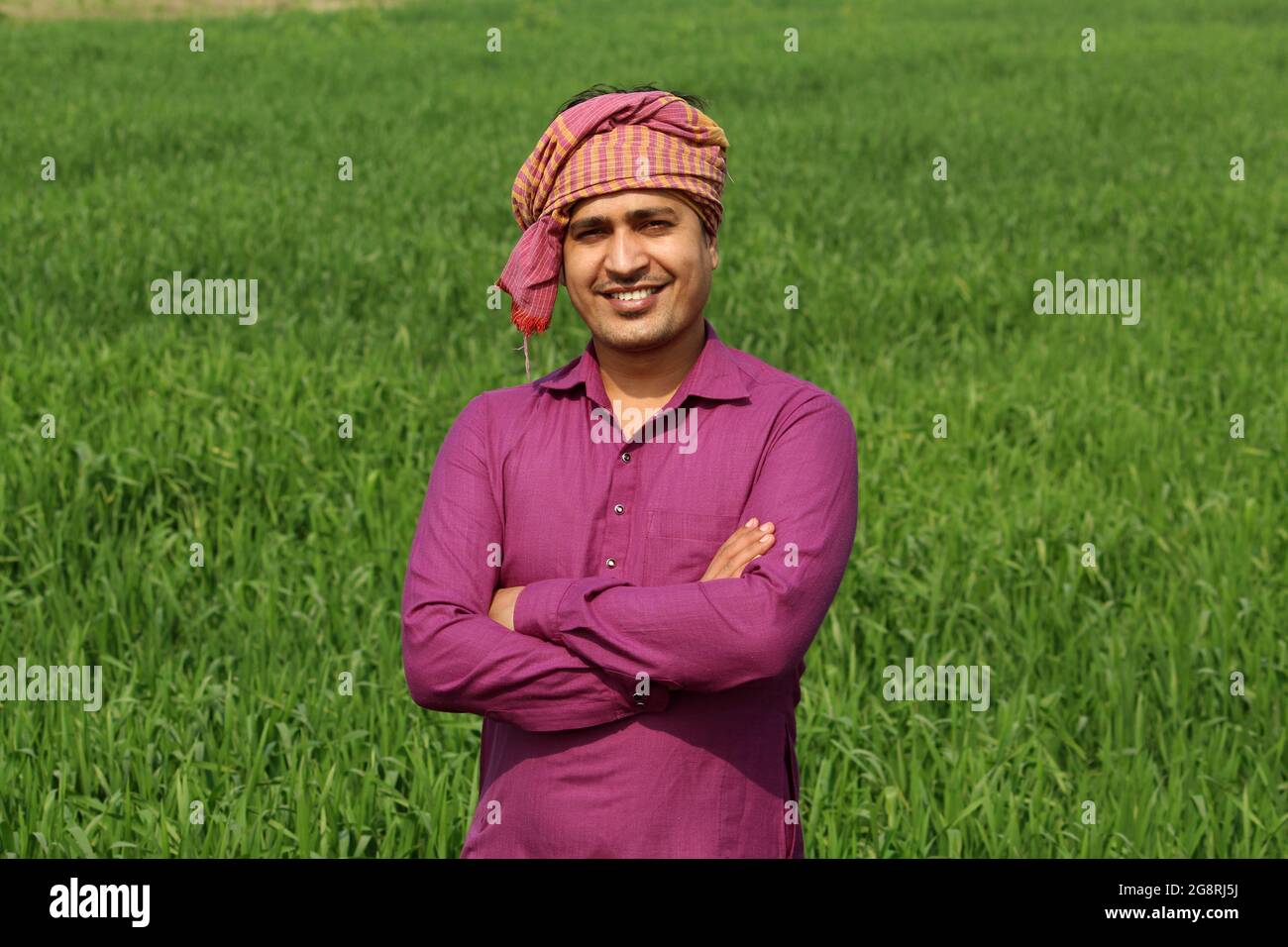 worry less ,indian farmer standing hand folded in his healthy wheat ...