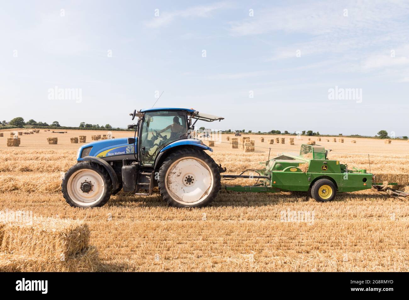 Riverstick, Cork, Ireland. 22nd July, 2021. Violet Buckley Draper baling straw with a John Deere 459 on the family farm. In all they will bale over 3,000 square bales before switching over to round onesat their farm in Riverstick, Co. Cork, Ireland. - Picture; Credit: David Creedon/Alamy Live News Stock Photo