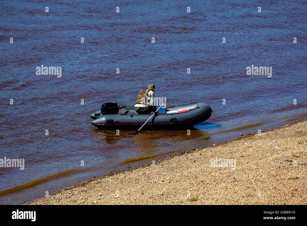 Motor boat with a man in coastal waters. Tourism by water transport. Hunting and fishing on a motor boat. Stock Photo