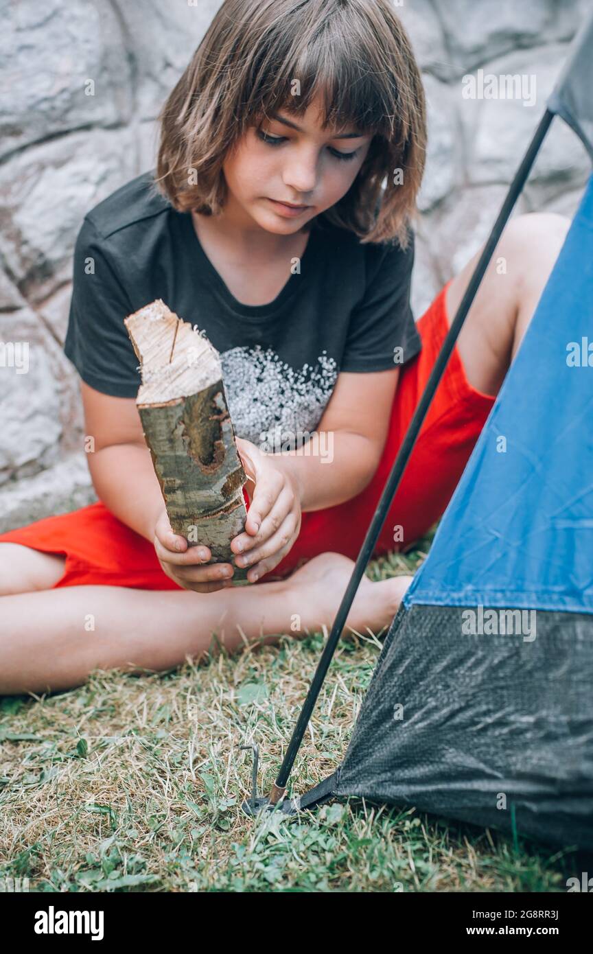 Boy in nature, in the forest sets up a tent and equips a bivouac ...