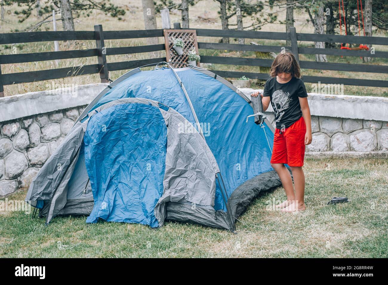Boy in nature, in the forest sets up a tent and equips a bivouac ...