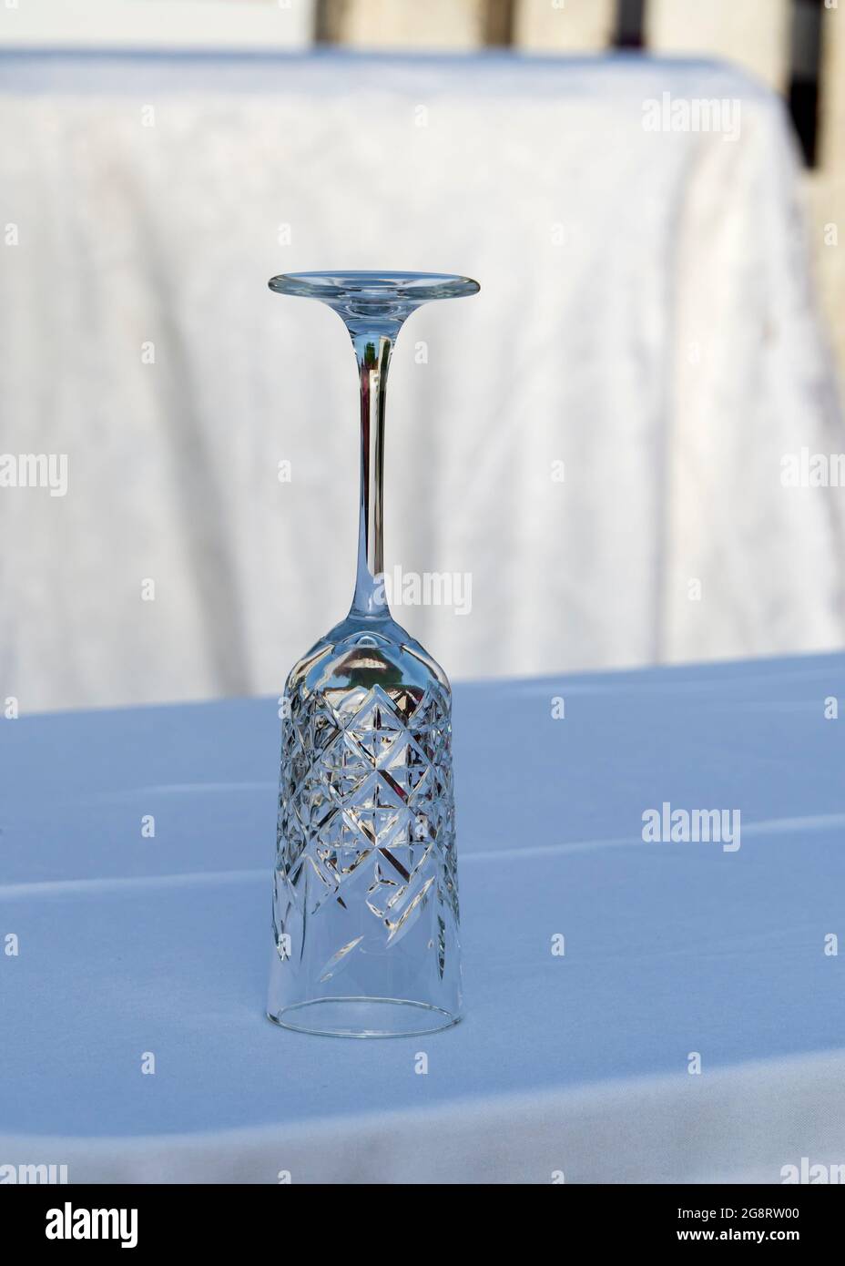 Glass cup on a table with a tablecloth on top of it Stock Photo