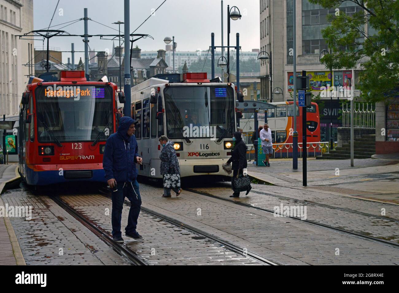 SHEFFIELD. SOUTH YORKSHIRE. ENGLAND. 07-10-21. Fitzalan Square tramstop in the city centre, two trams passing in the rain. Stock Photo