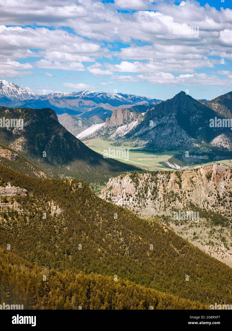 Chief Joseph Byway in Wyoming at Dead Indian Overlook with mountains, snow, clouds, forests, valley and road. Stock Photo