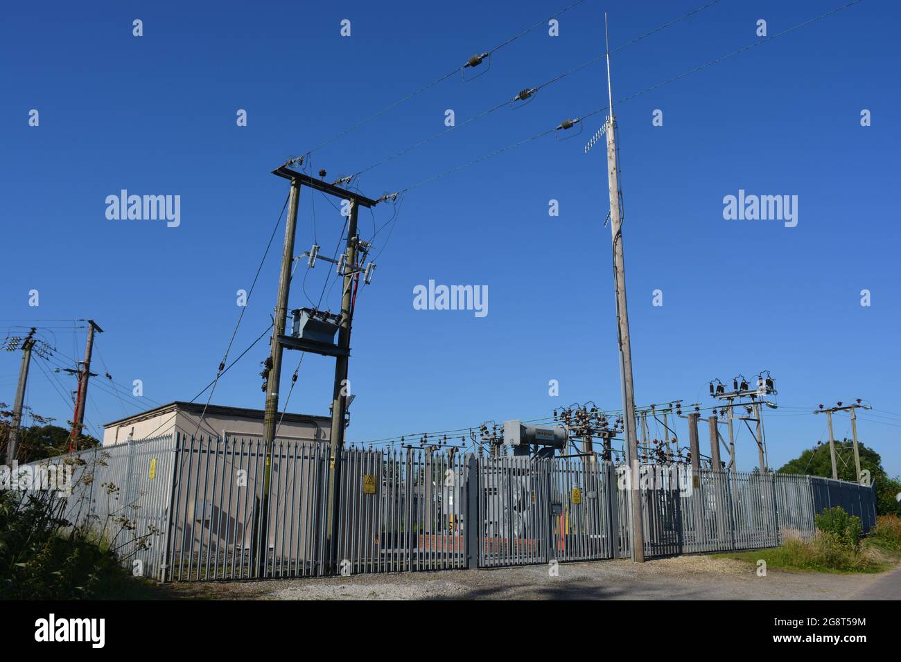 Electricity substation with warning signs on perimeter fence Stock Photo