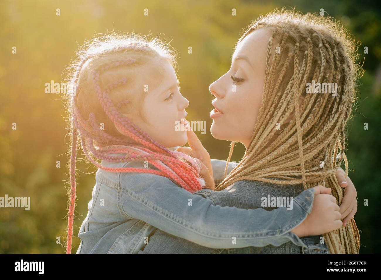 Family and motherhood concept. Mother and child girl playing kissing and hugging. Little daughter hugging her happy mother Stock Photo