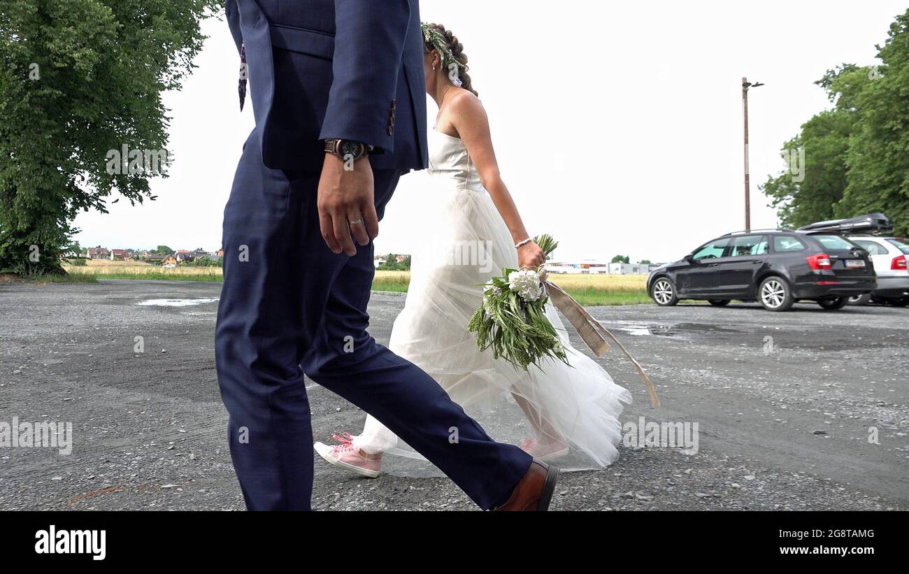 Close-up of the bride and the groom walk on the path. Stock Photo