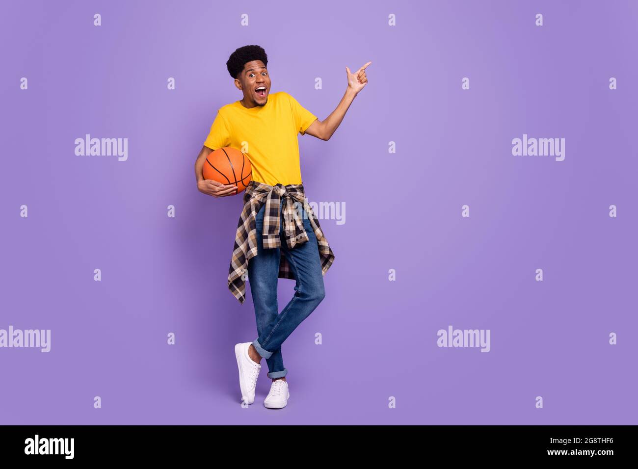 Full body photo of young afro american man wear denim jeans point finger empty space basketball