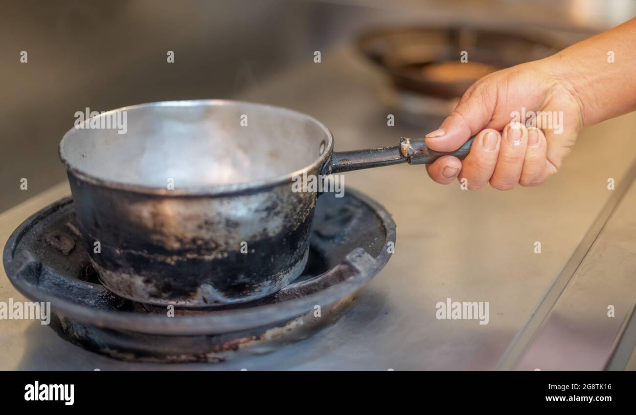 https://c8.alamy.com/comp/2G8TK16/female-hand-holding-a-pot-prepare-to-cooking-in-the-kitchen-in-the-restaurant-2G8TK16.jpg