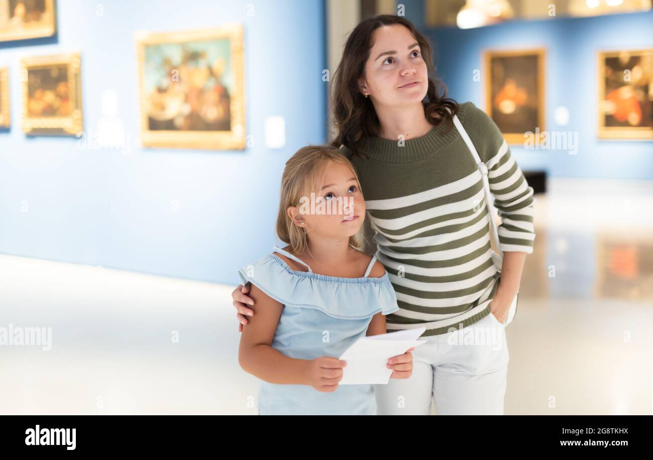 Woman with girl looking at modern painting in museum of art Stock Photo ...