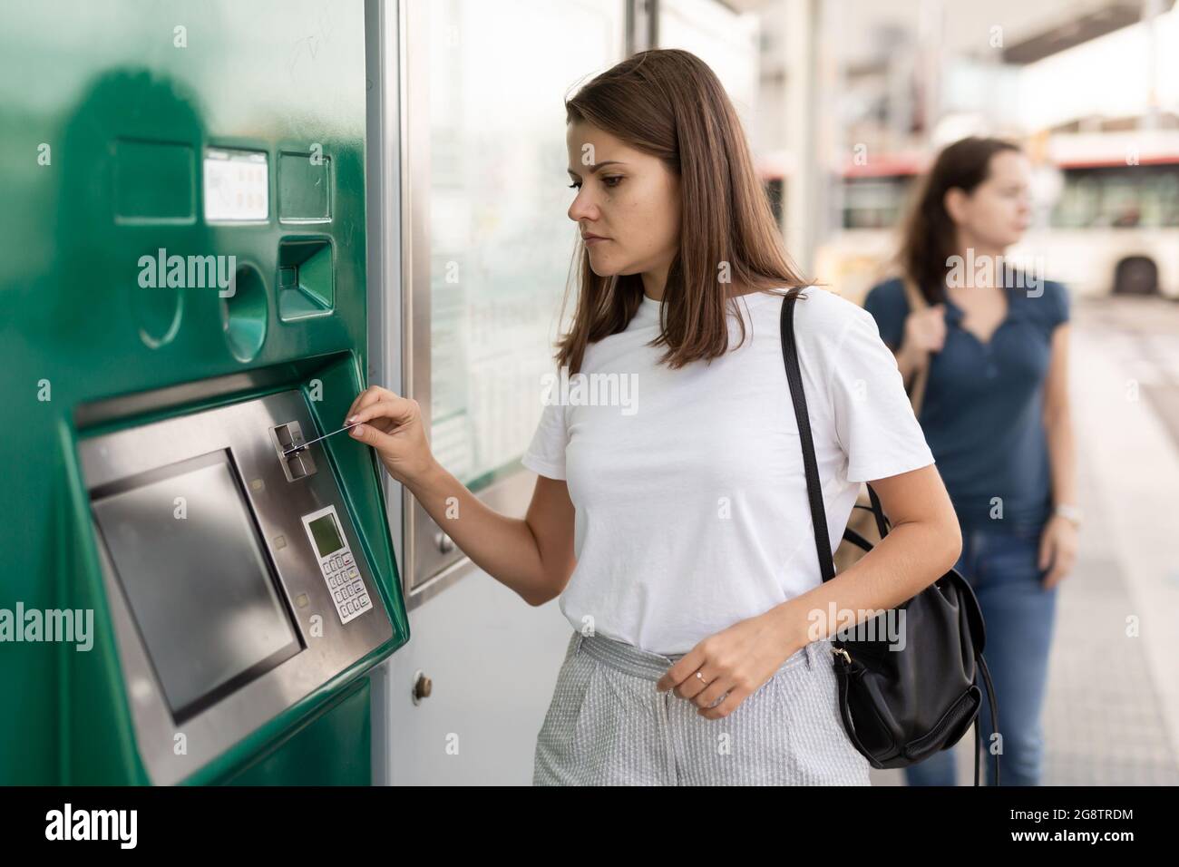 Woman using ticket vending machine at tram stop Stock Photo - Alamy