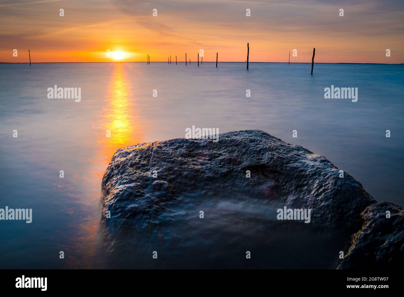 Beautiful sunset view at the Lake IJssel with fishing net poles in  Flevoland, the Netherlands Stock Photo - Alamy
